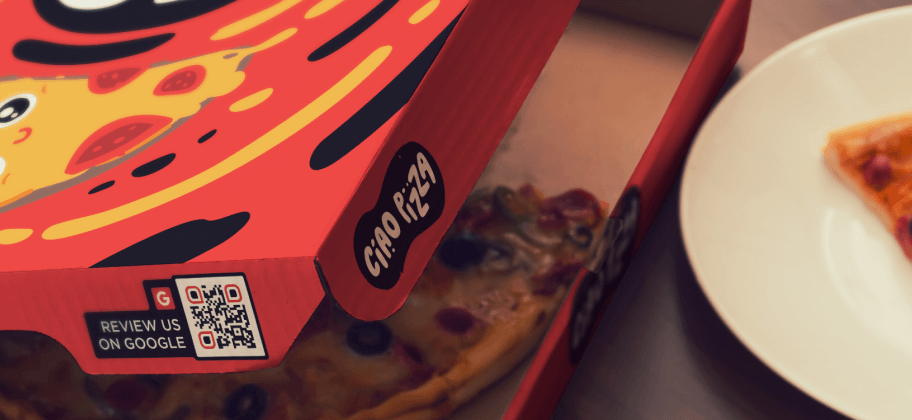 Una scatola di pizza con un QR Code sul lato.