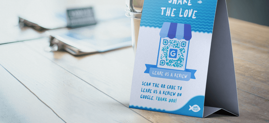 Un espositore da tavolo con un QR Code per lasciare una recensione su Google.