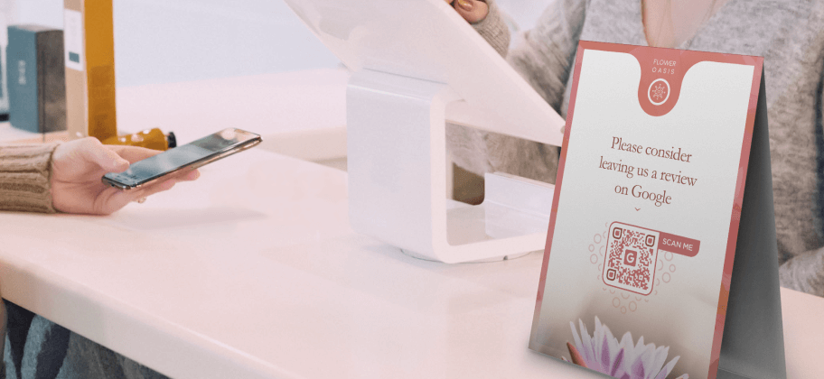 Un espositore da tavolo alla reception di un centro benessere con un QR Code Recensioni di Google.